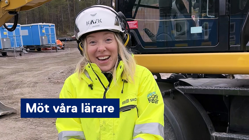 Glad lärare, Johanna Jonasson, i gula varselkläder och vit hjälm framför en grävmaskin.